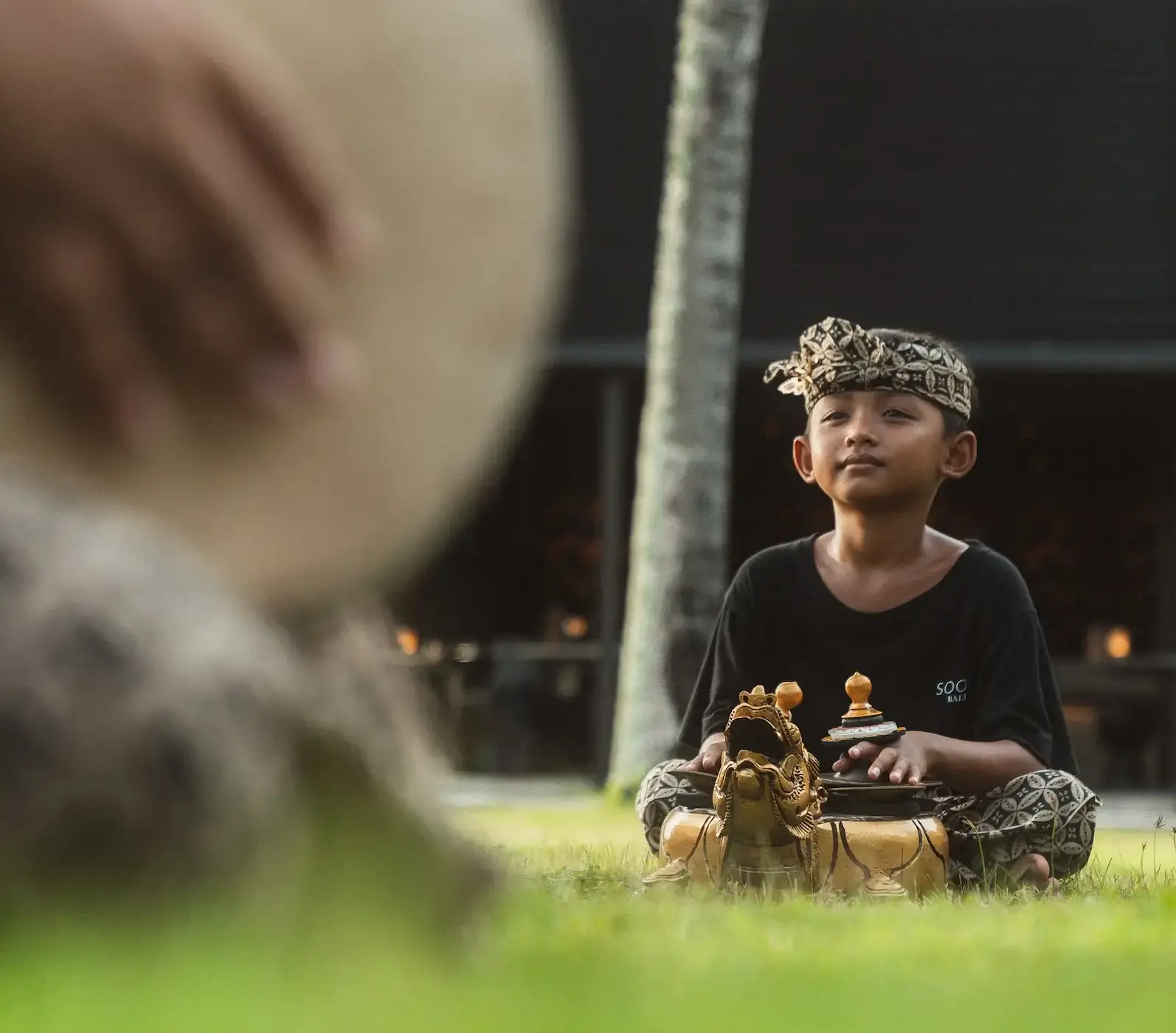Balinese dance teacher guiding children during an outdoor rehearsal